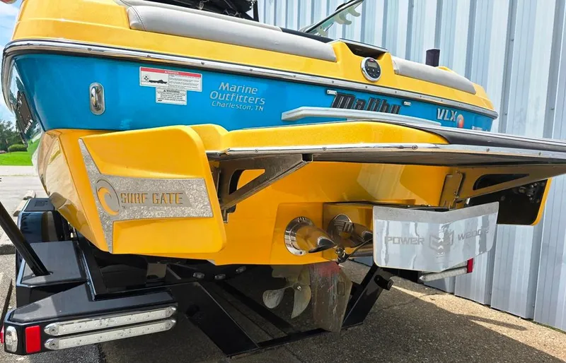Slide: The Image of 2015 Malibu Wakesetter 22 VLX Surf Gate boat, yellow and blue, rear view. - 7