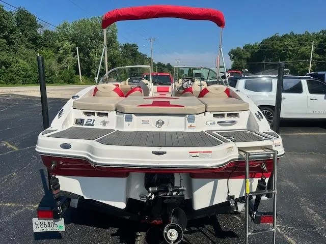 Slide: The Image of 2018 Chaparral 21 H2O Ski & Fish boat with red canopy, parked on asphalt. - 2