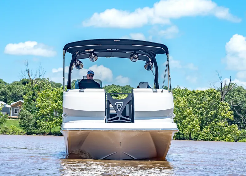 Slide: The Image of 2025 Paradigm Damascus 266 Surf boat on water, clear sky, lush greenery background. - 4