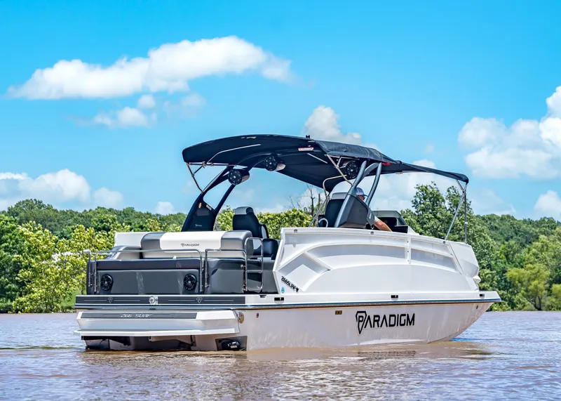 Slide: The Image of 2025 Paradigm Damascus 266 Surf boat on a sunny lake, featuring sleek design and canopy. - 8