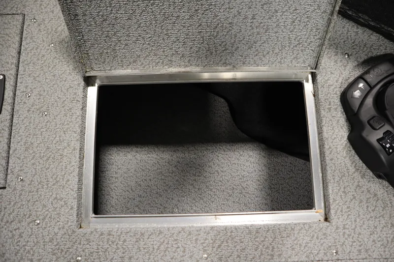 Slide: The Image of 2024 Crestliner 1950 Fish Hawk WT storage compartment with textured flooring and control panel. - 21