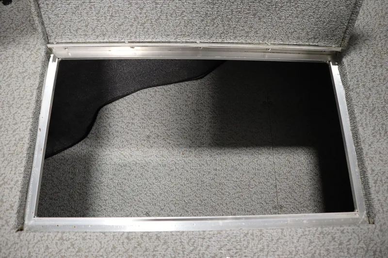 Slide: The Image of 2024 Crestliner 1950 Fish Hawk WT storage compartment with gray carpet interior. - 25