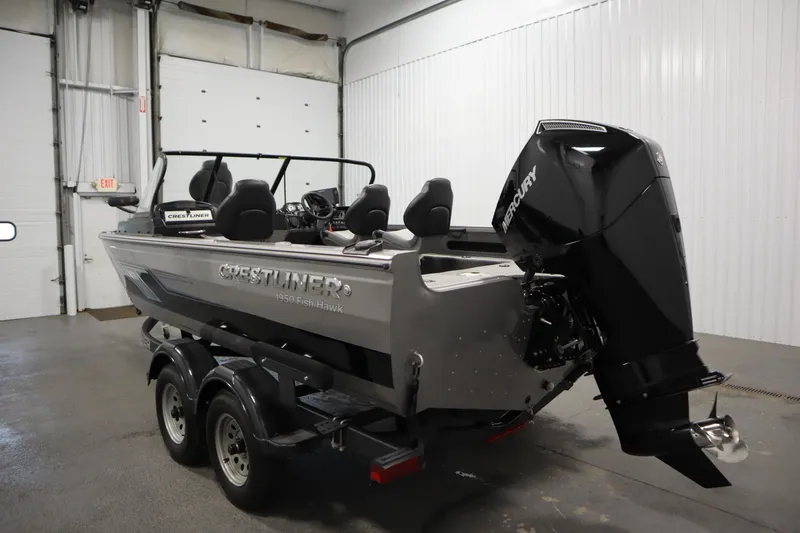 Slide: The Image of 2024 Crestliner 1950 Fish Hawk WT boat with Mercury outboard motor in a garage. - 7