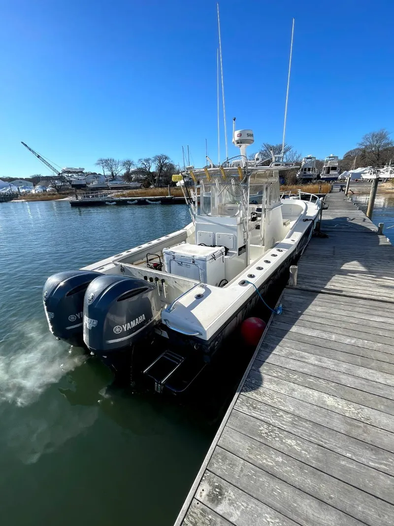 Slide: The Image of 1998 Ocean Master 31 Center Console boat docked with twin Yamaha engines. - 2