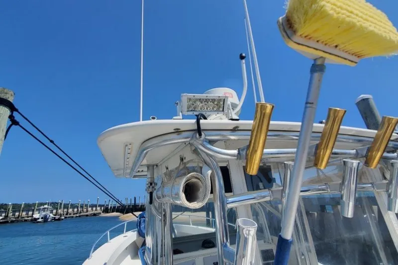 Slide: The Image of 1998 Ocean Master 31 Center Console boat docked, featuring fishing rod holders and cleaning brush. - 22