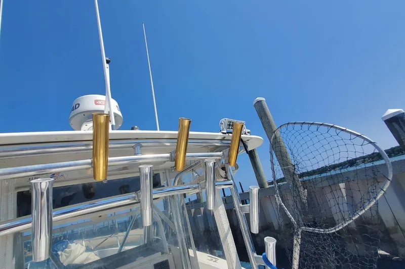 Slide: The Image of 1998 Ocean Master 31 Center Console with fishing rod holders and net under clear blue sky. - 26
