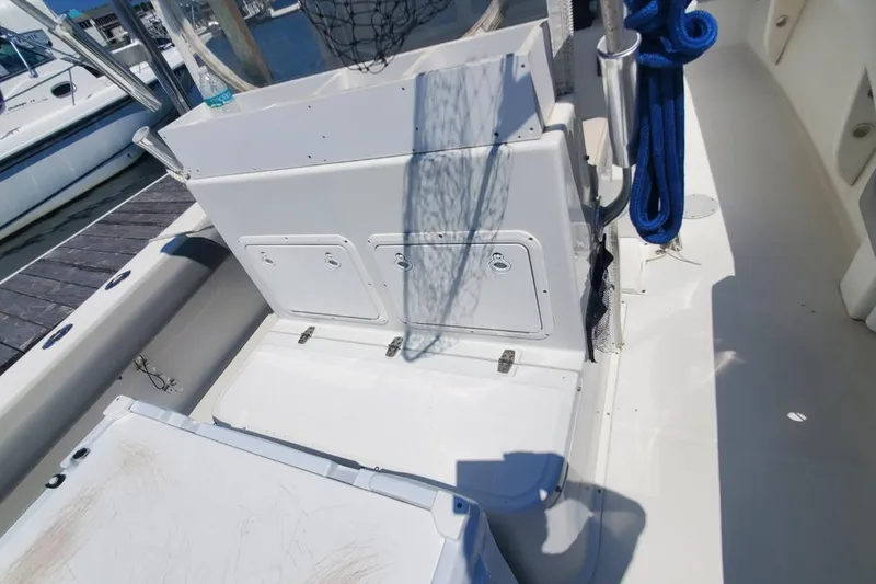 Slide: The Image of 1998 Ocean Master 31 Center Console boat interior with storage compartments and blue rope. - 7