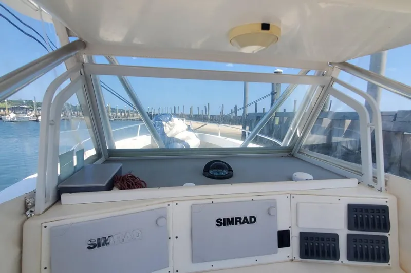 Slide: The Image of 1998 Ocean Master 31 Center Console boat interior with Simrad equipment, docked at marina. - 9