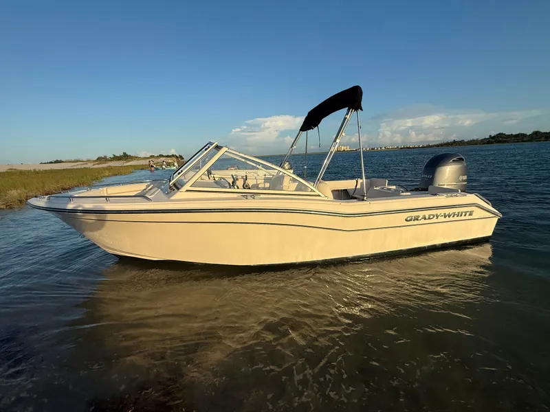 Slide: The Image of 2020 Grady-White Freedom 192 boat on calm water under clear blue sky. - 1