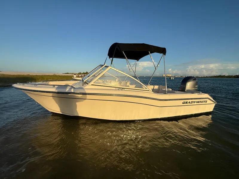 Slide: The Image of 2020 Grady-White Freedom 192 boat on calm water at sunset. - 2