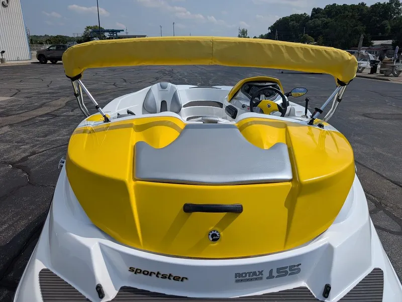 Slide: The Image of 2006 Sea-Doo 150 Sportster boat with yellow and white design, parked outdoors. - 12