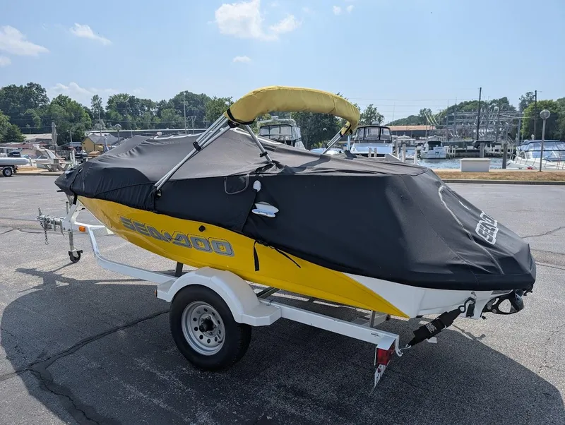 Slide: The Image of 2006 Sea-Doo 150 Sportster boat with cover on trailer, parked near marina. - 18