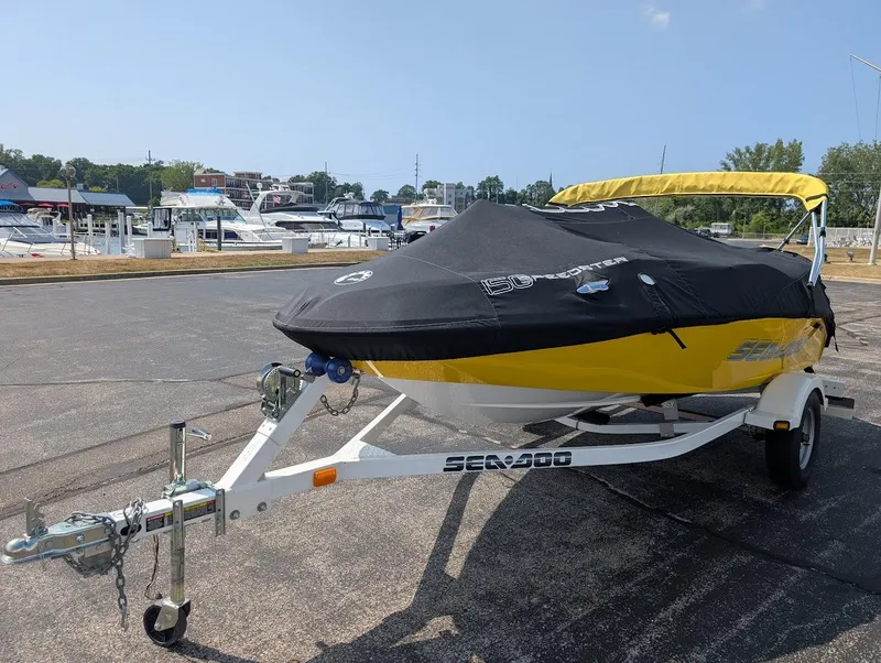Slide: The Image of 2006 Sea-Doo 150 Sportster boat on trailer, covered, parked near marina. - 19