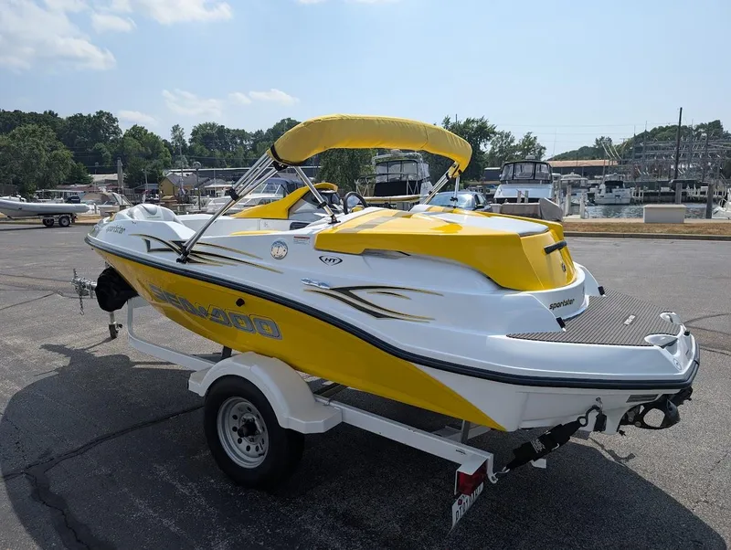 Slide: The Image of 2006 Sea-Doo 150 Sportster boat in yellow, parked on a trailer at a marina. - 6