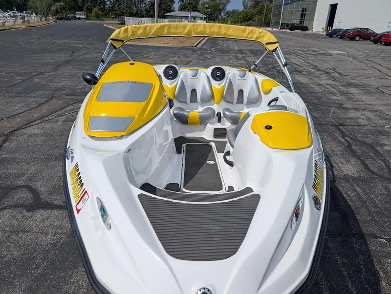 Slide: The Image of 2006 Sea-Doo 150 Sportster boat with yellow accents, parked on asphalt. - 7