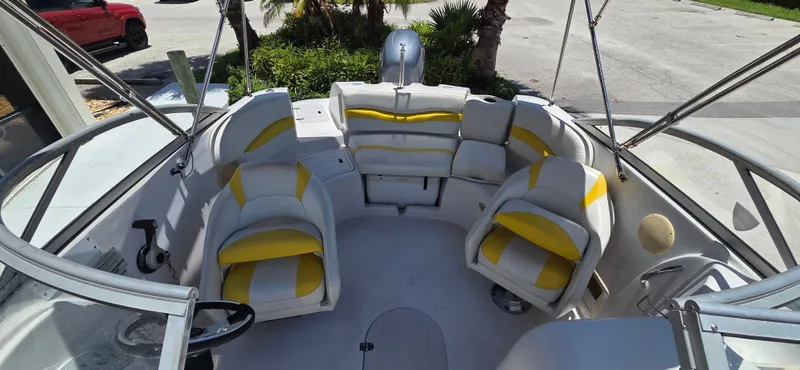 Slide: The Image of 2008 Starcraft 2210 OB Limited boat interior with yellow and white seating, parked outdoors. - 14