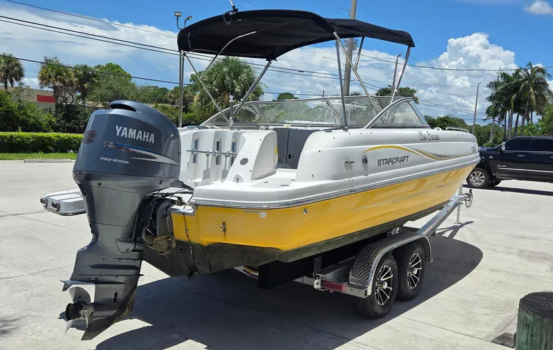 Slide: The Image of 2008 Starcraft 2210 OB Limited boat with Yamaha engine on trailer, parked outdoors. - 2
