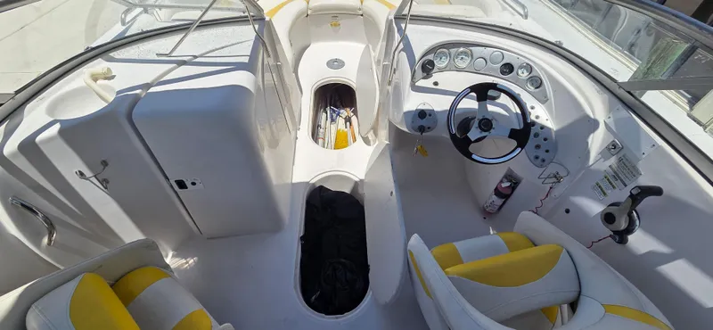 Slide: The Image of 2008 Starcraft 2210 OB Limited boat interior with steering wheel and yellow-accented seats. - 9