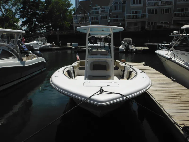 Slide: The Image of 2022 Tidewater 220 LXF boat docked at a marina, surrounded by other boats. - 3