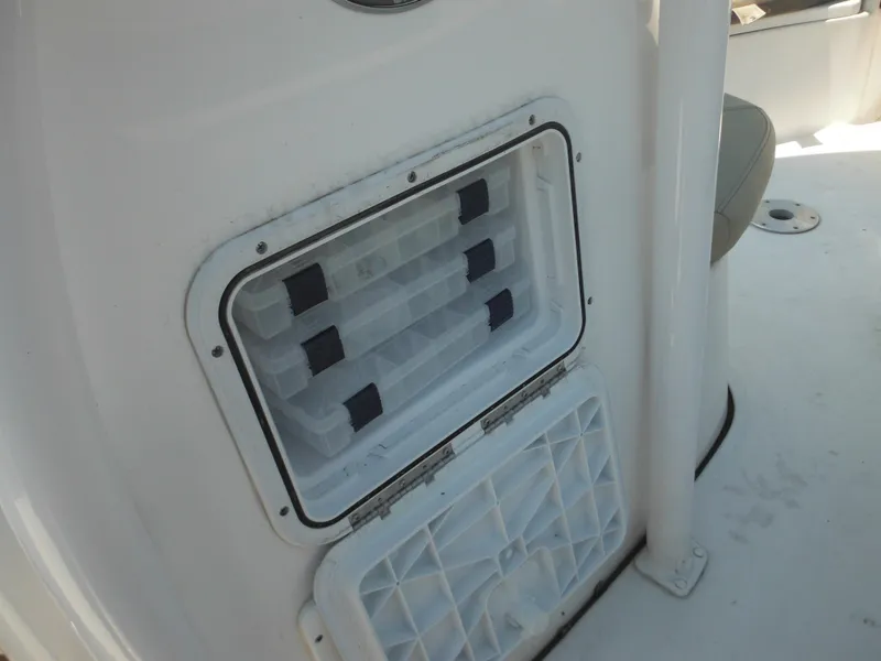 Slide: The Image of Tidewater 220 LXF 2022 boat storage compartment with organized tackle boxes. - 35