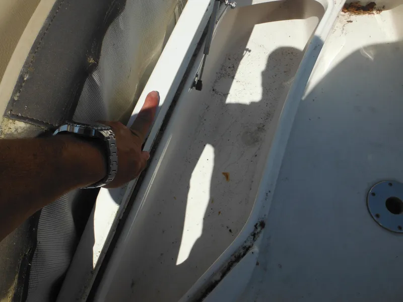Slide: The Image of Close-up of a 2022 Tidewater 220 LXF boat interior, showing a hand pointing at a compartment. - 39