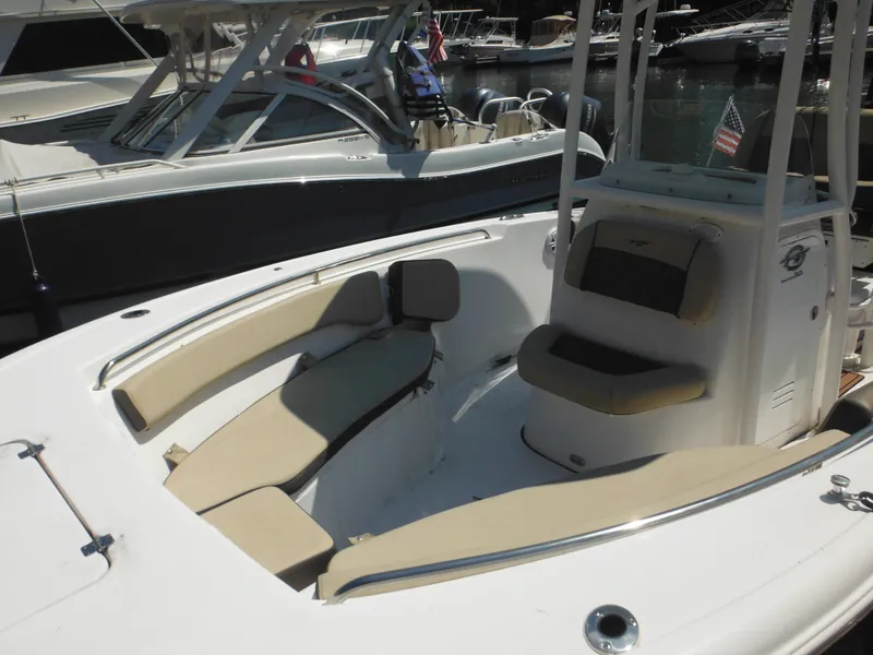 Slide: The Image of 2022 Tidewater 220 LXF boat with beige seating, docked in a marina. - 4