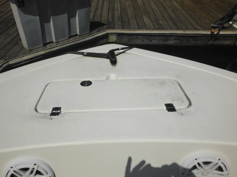 Slide: The Image of Bow of 2022 Tidewater 220 LXF boat docked, featuring storage hatch and speakers. - 40