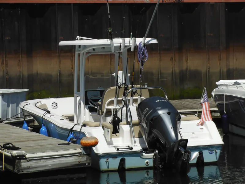 Slide: The Image of 2022 Tidewater 220 LXF boat docked with fishing rods and American flag. - 44