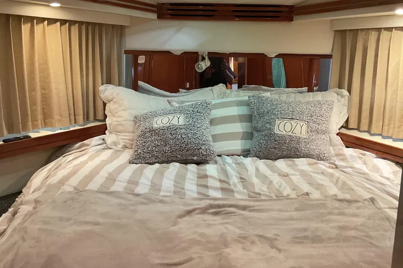 Slide: The Image of Cozy bedroom interior of 2000 Carver 530 Voyager Pilothouse with striped bedding and pillows. - 16
