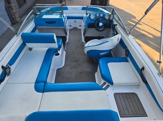 Slide: The Image of 2015 Bryant Sportabout boat interior with blue and white seating, steering wheel, and dashboard. - 7