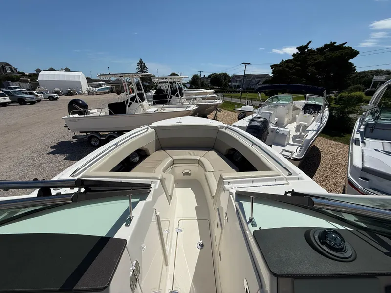 Slide: The Image of 2021 Boston Whaler 240 Vantage boat displayed in a marina with other vessels. - 10