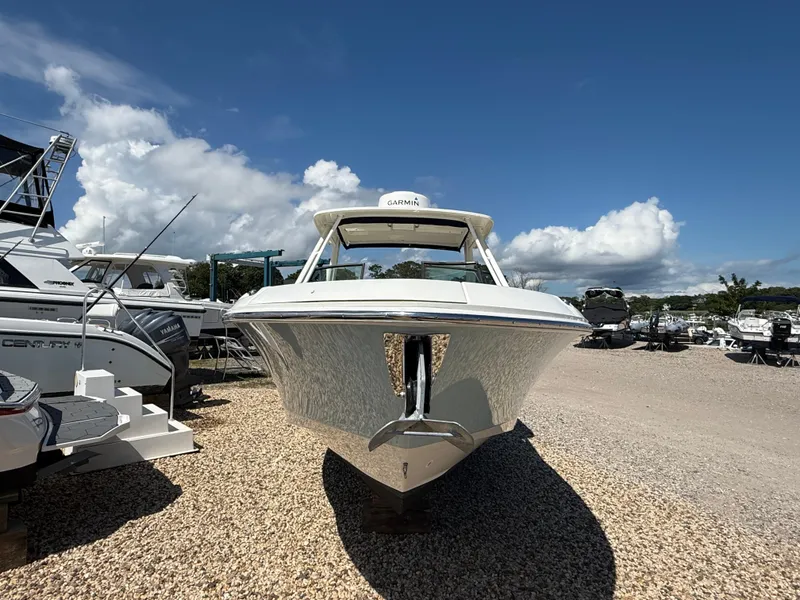 Slide: The Image of 2021 Boston Whaler 240 Vantage boat displayed outdoors on gravel under a clear blue sky. - 12