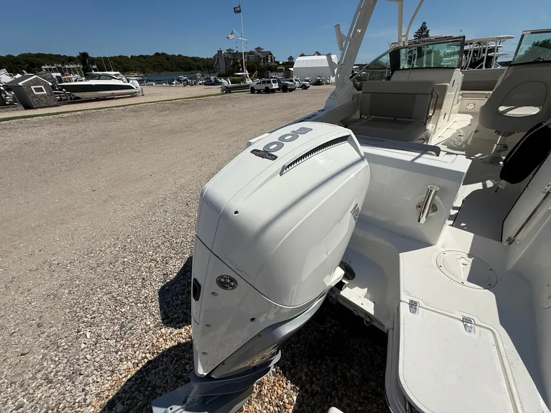 Slide: The Image of 2021 Boston Whaler 240 Vantage boat with powerful outboard motor in a marina setting. - 2