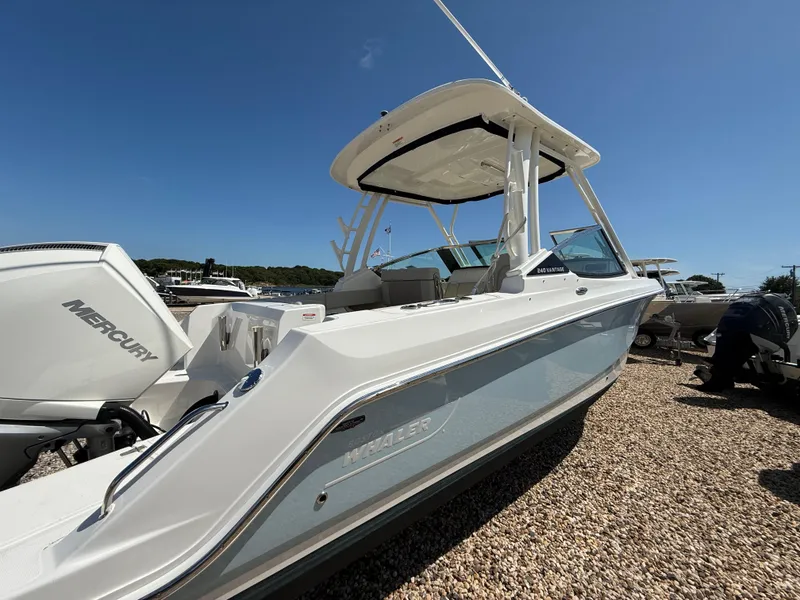 Slide: The Image of 2021 Boston Whaler 240 Vantage boat with Mercury engine, displayed outdoors on gravel. - 4