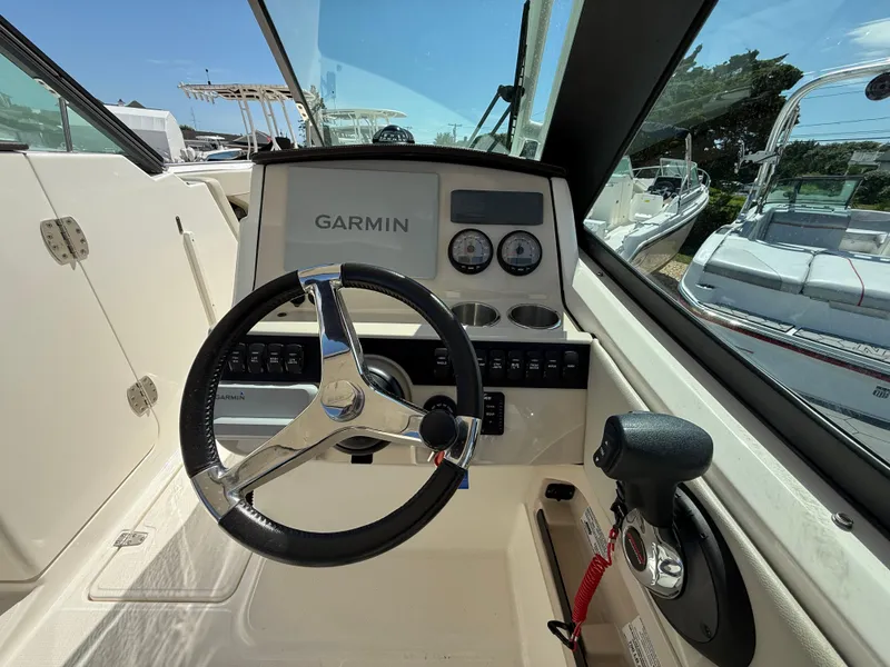 Slide: The Image of Helm of 2021 Boston Whaler 240 Vantage with Garmin navigation system and steering wheel. - 8