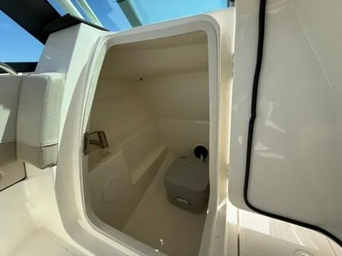 Slide: The Image of 2021 Boston Whaler 240 Vantage interior cabin with seating and storage space. - 9