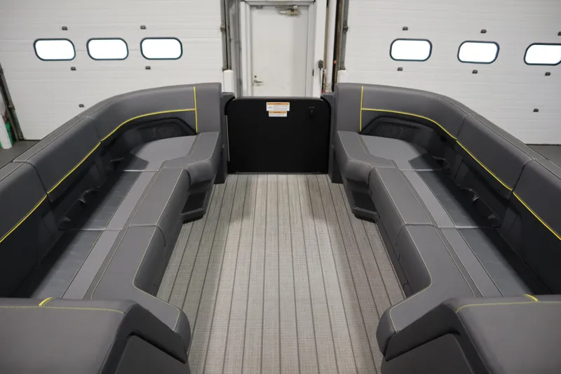 Slide: The Image of 2025 Manitou 24 EXPLORE SWITCHBACK TRIFOLD TRITOON interior with gray seating and yellow accents. - 11