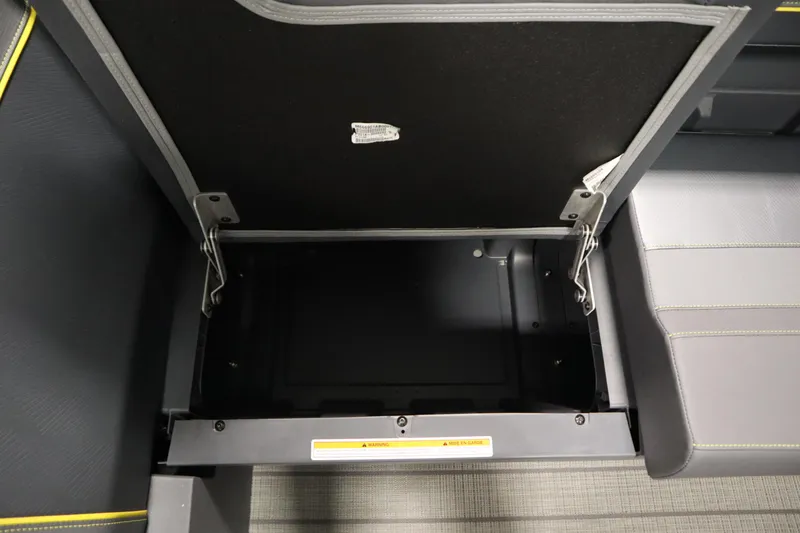 Slide: The Image of Open storage compartment in 2025 Manitou 24 Explore Switchback Trifold Tritoon boat. - 13