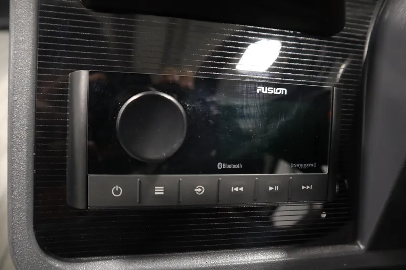 Slide: The Image of Fusion audio system in 2025 Manitou 24 Explore Switchback Trifold Tritoon, featuring Bluetooth and SiriusXM. - 25
