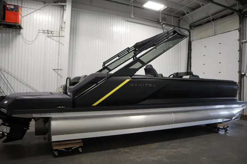 Slide: The Image of 2025 Manitou 24 Explore Switchback Trifold Tritoon in a showroom setting. - 4