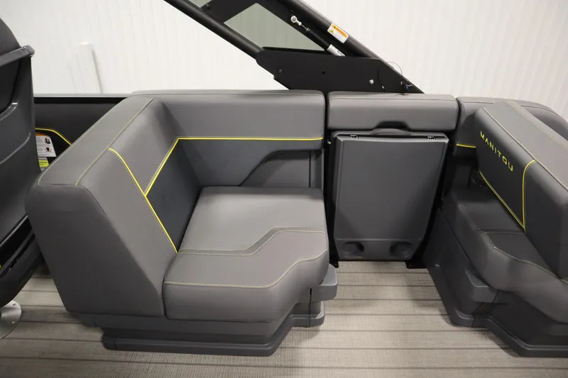 Slide: The Image of 2025 Manitou 24 Explore Switchback Tritoon interior seating with sleek gray upholstery and yellow accents. - 43