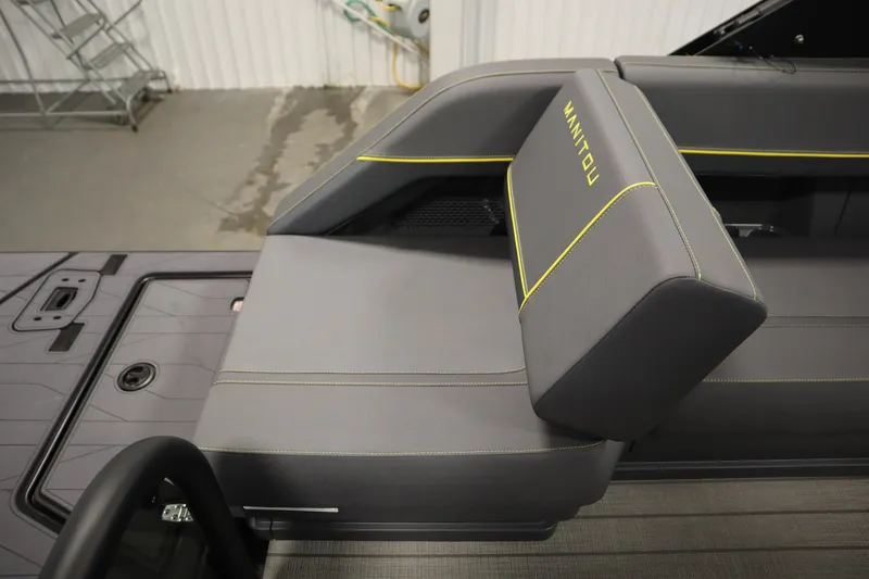 Slide: The Image of 2025 Manitou 24 Explore Switchback Tritoon interior seating with gray upholstery and yellow accents. - 47