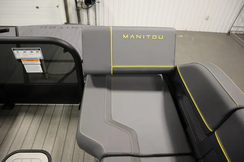 Slide: The Image of 2025 Manitou 24 Explore Switchback Tritoon, gray seating with yellow stitching detail. - 48