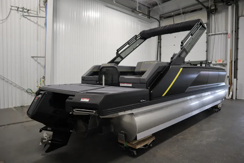 Slide: The Image of 2025 Manitou 24 Explore Switchback Trifold Tritoon in a warehouse setting. - 5