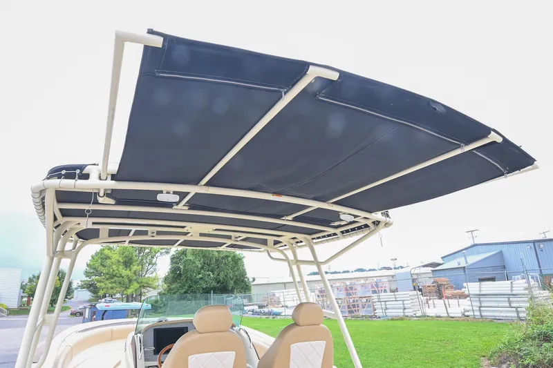 Slide: The Image of 2016 Chris-Craft Catalina 29 boat with black canopy and beige seating. - 22