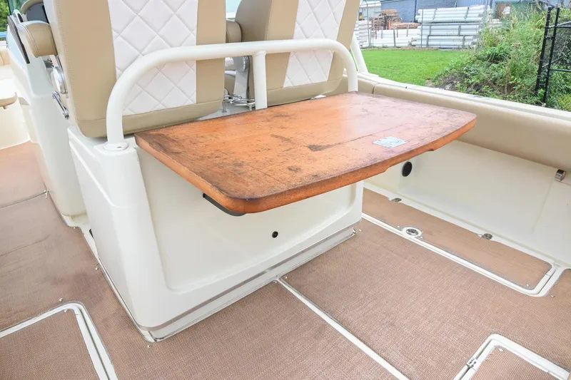 Slide: The Image of 2016 Chris-Craft Catalina 29 interior with wooden table and beige seating. - 24