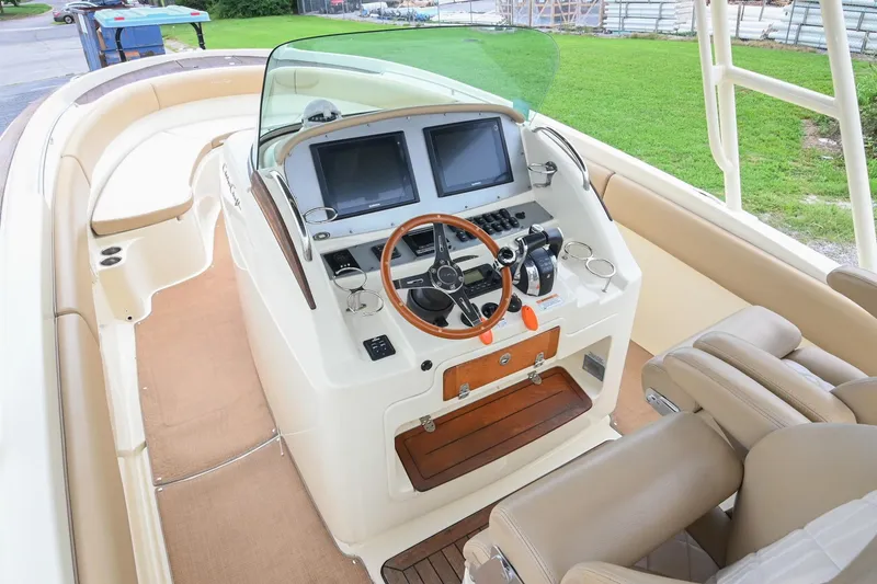 Slide: The Image of 2016 Chris-Craft Catalina 29 boat interior with helm, dual screens, and leather seating. - 28