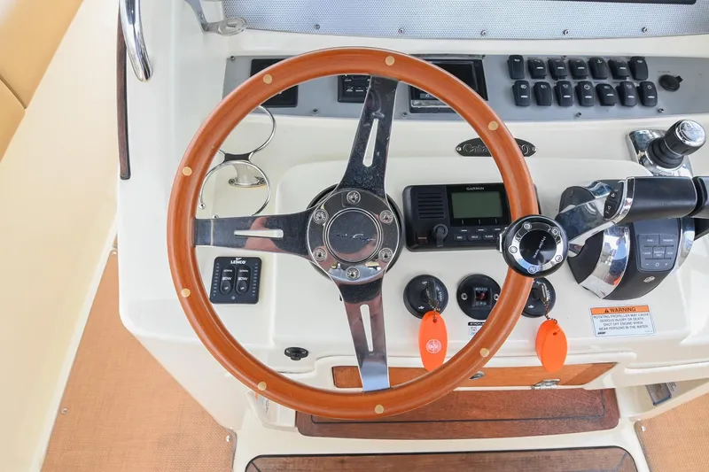 Slide: The Image of Steering wheel and controls of 2016 Chris-Craft Catalina 29 boat cockpit. - 31