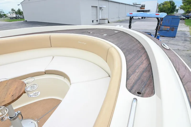 Slide: The Image of 2016 Chris-Craft Catalina 29 boat interior with cushioned seating and wooden accents. - 42