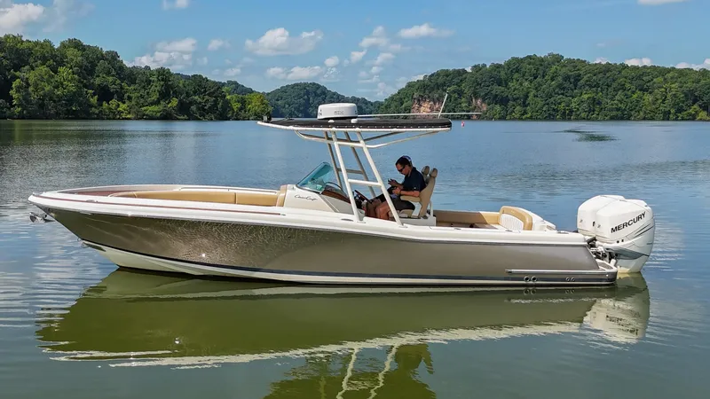 Slide: The Image of 2016 Chris-Craft Catalina 29 boat on a calm lake with lush green surroundings. - 48